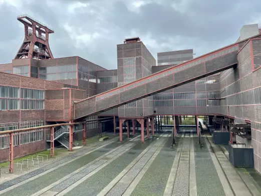 Цольферайн, шахта XII. Спроектирована в стиле Баухауса и запущена в 1932 году — на тот момент крупнейшая и самая производительная угольная шахта в Европе. Слева — копер шахты XII, один из самых узнаваемых индустриальных силуэтов Германии. С 2001 года — объект Всемирного наследия ЮНЕСКО.